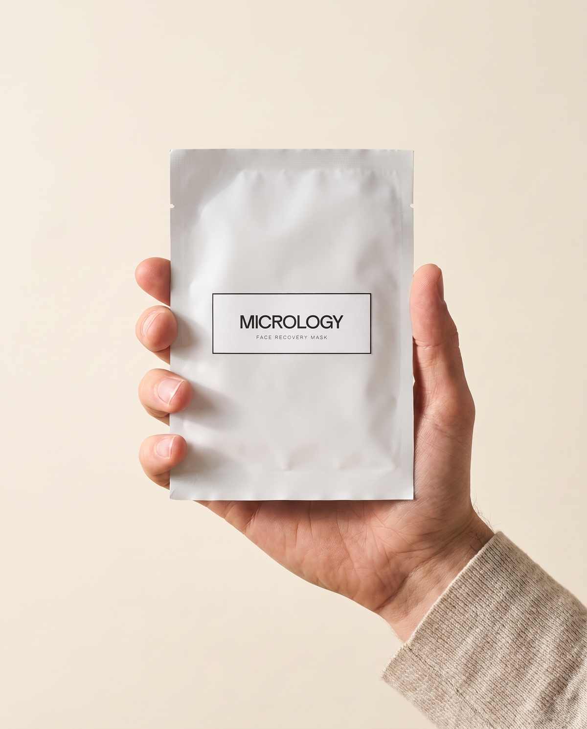 Hand hält ein Sachet der Micrology Face Recovery Mask